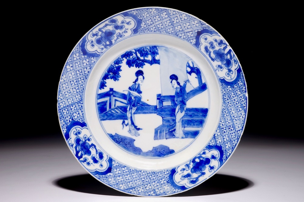 Une assiette en porcelaine de Chine bleu et blanc &agrave; d&eacute;cor de &quot;dames longues&quot; dans un jardin, Kangxi