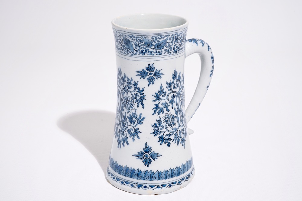 Une chope en fa&iuml;ence de Delft bleu et blanc aux rinceaux de lotus de style Ming, fin du 17&egrave;me