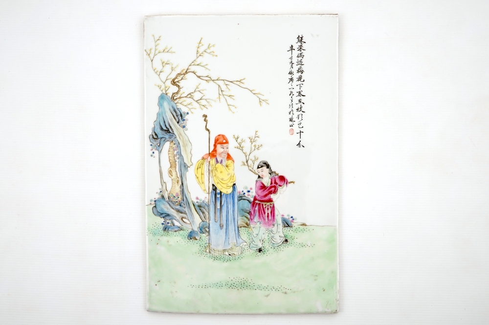 Een Chinese famille rose plaque met twee personages in een tuin, 19/20e