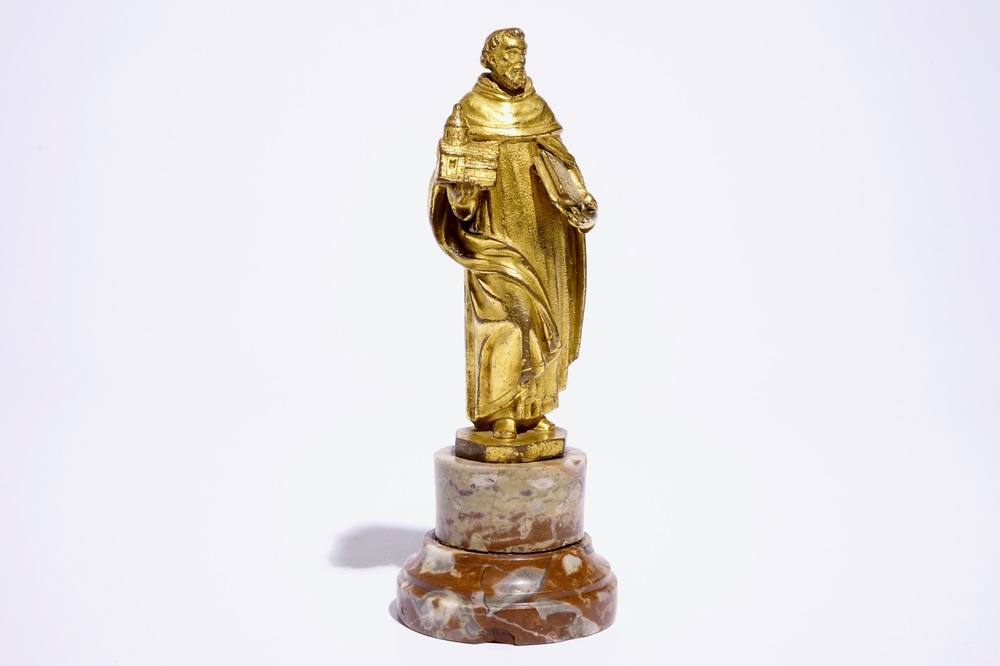 A gilt bronze model of a saint on a later marble base, 17th C.