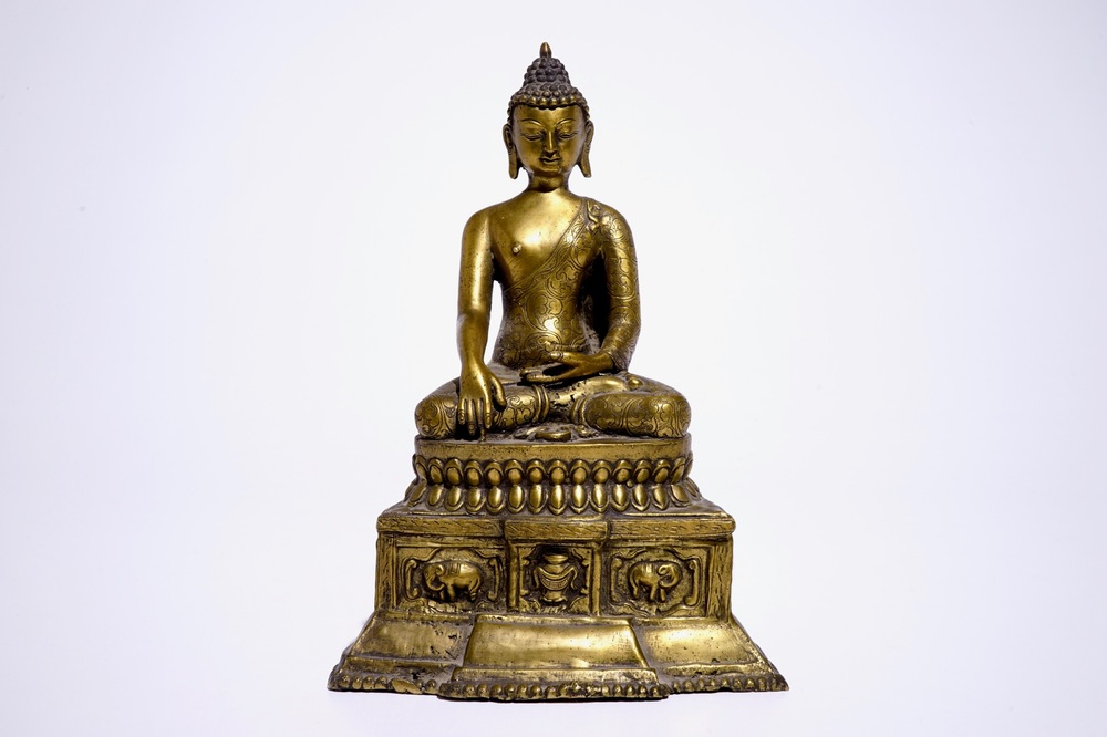 A gilt bronze model of Buddha seated on a throne, Nepal or Tibet, 19/20th C.