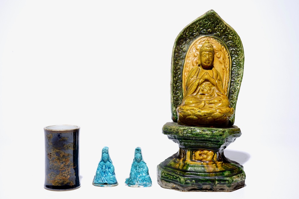 A Chinese sancai Buddha on a throne, two turquoise Guanyin figures and a black and gilt brushpot, 18/19th C.