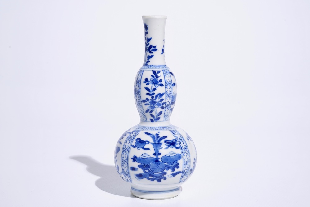 Een Chinees blauw-wit dubbel gourde vaasje met kostbaarhedendecor, Kangxi