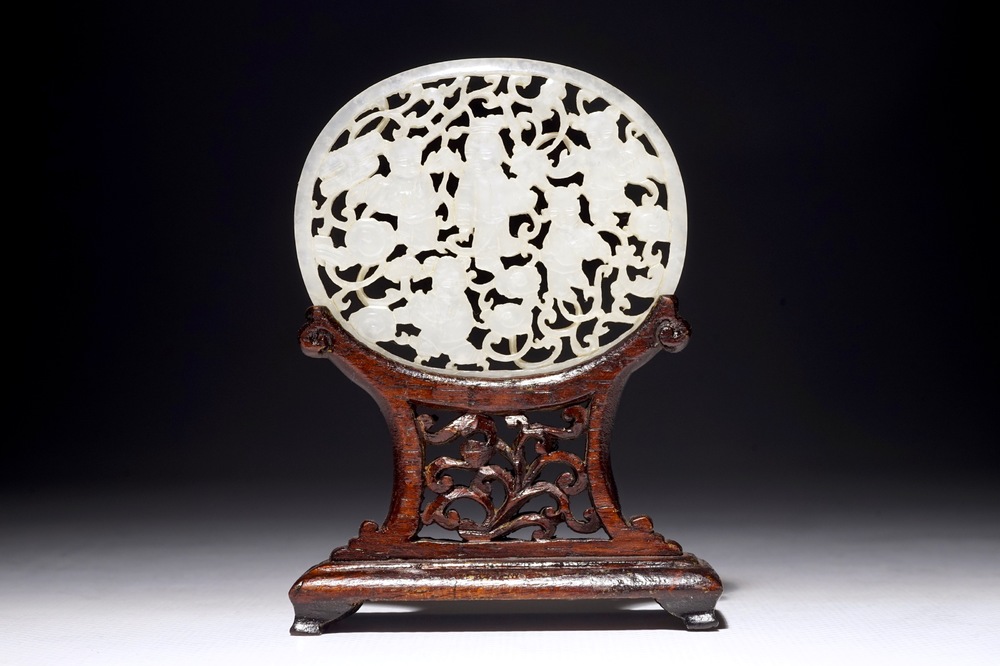 A Chinese reticulated jade plaque, on wooden stand, 19th C.