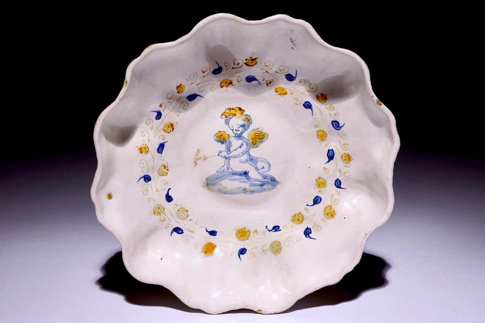 An Italian maiolica crespina with a putto, Faenza, early 17th C.