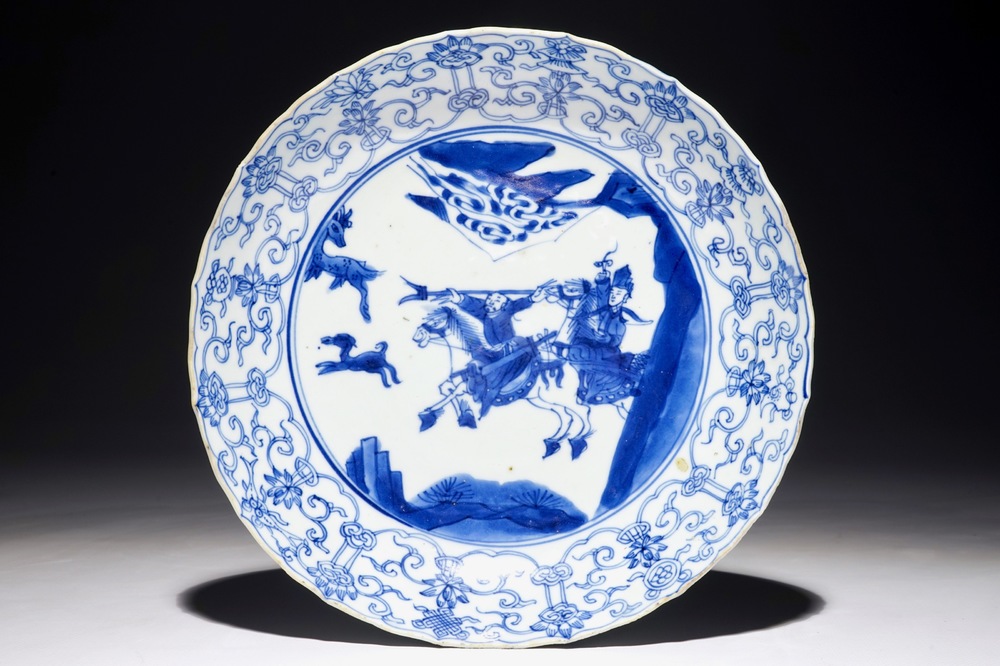 Een blauw-wit Chinees gecontourneerd bord met een jachtsc&egrave;ne, Kangxi
