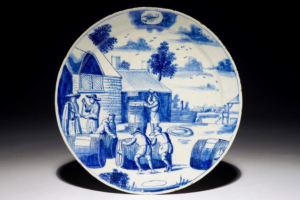 Une assiette en fa&iuml;ence de Delft bleu et blanc aux tonneliers de la s&eacute;rie des &quot;Zodiaques&quot;, d&eacute;but du 18&egrave;me