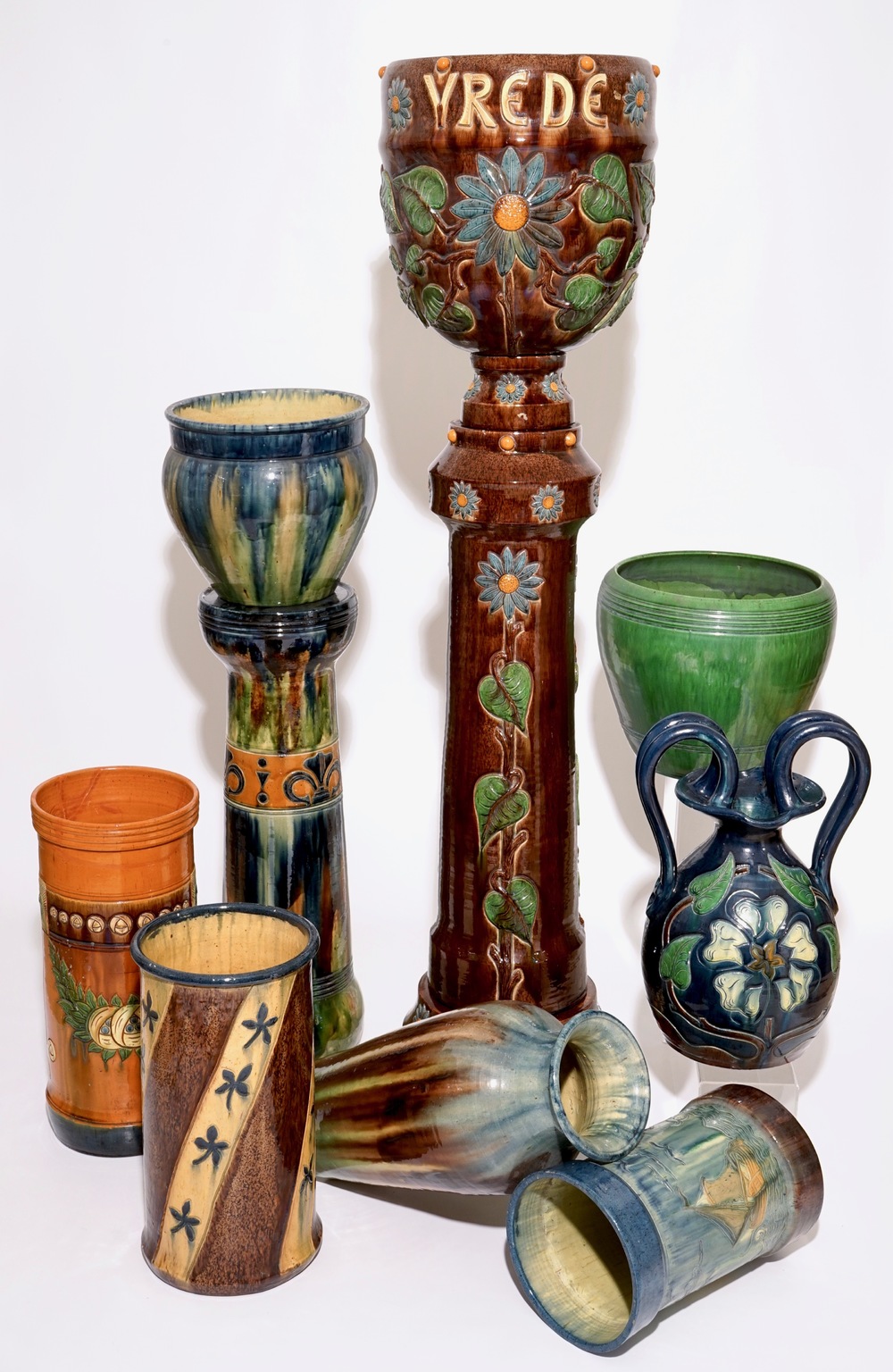 A large collection of Flemish pottery, mostly jardinieres on stands, early 20th C.