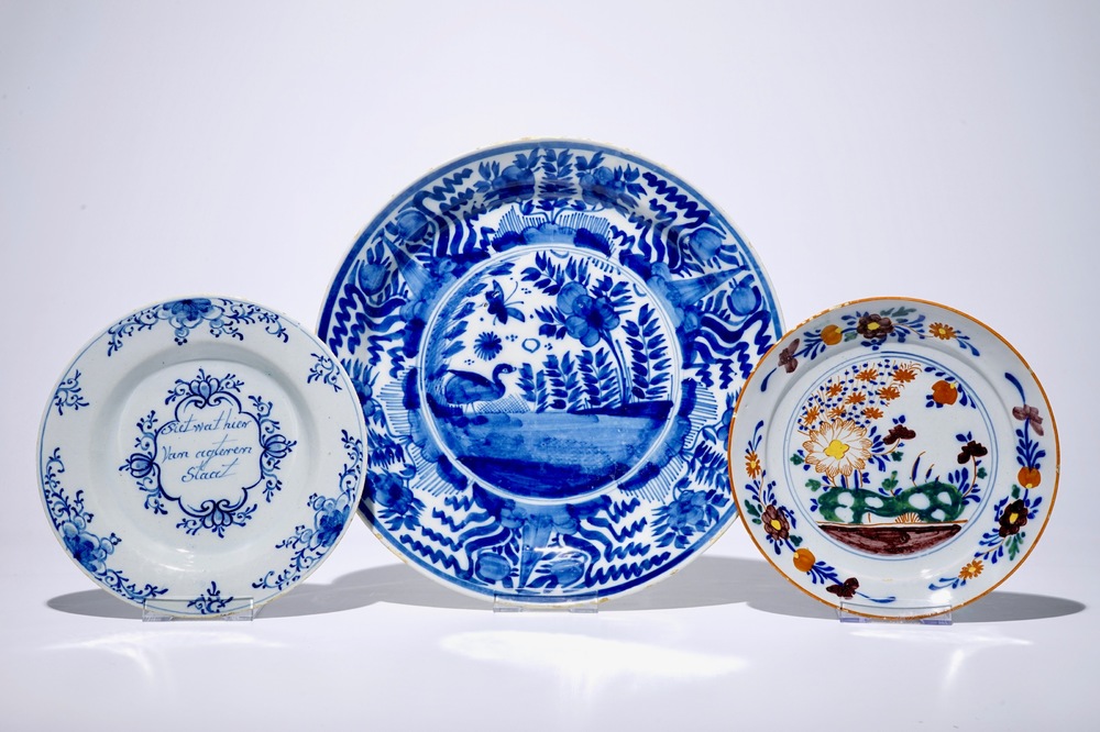 A Dutch Delft blue and white chinoiserie dish, an inscribed plate and a polychrome plate with floral design, 18th C.