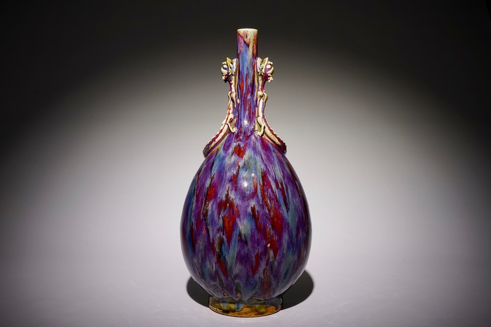 Een monochrome Chinese flamb&eacute; glazuur flesvormige vaas met draken, 19e eeuw