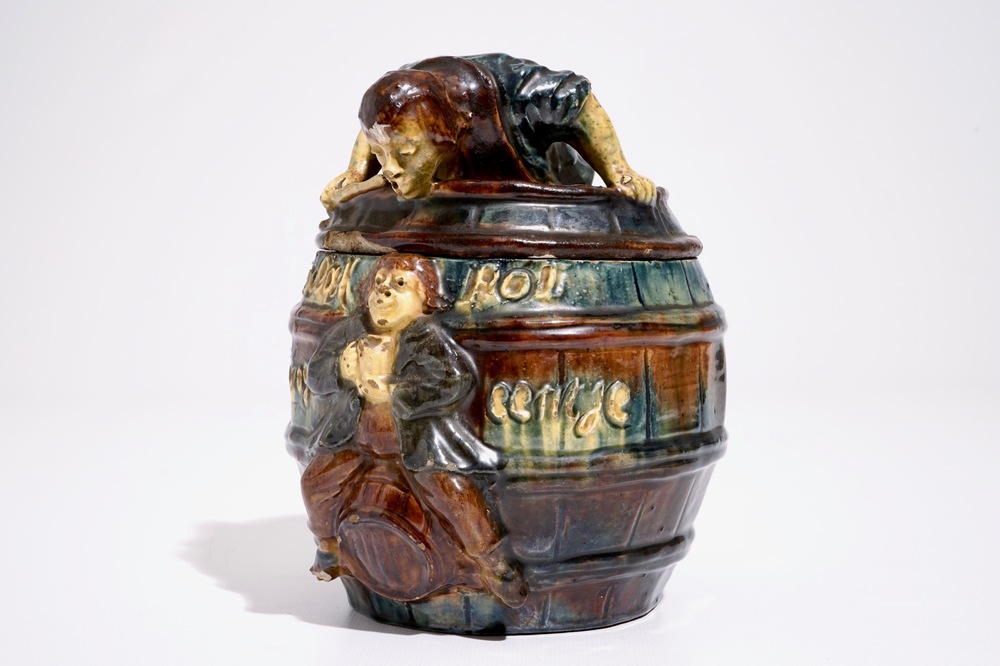 A Flemish pottery tobacco jar with a man in a barrel, prob. Vandevoorde workshop, 20th C.