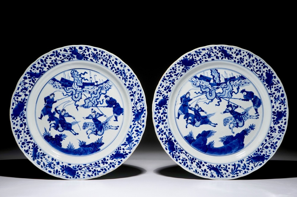 A pair of Chinese blue and white dishes with warriors on horseback, Kangxi