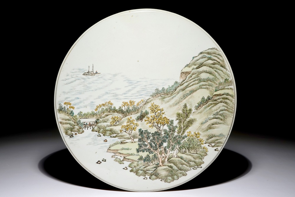 Une plaque ronde en porcelaine de Chine polychrome &agrave; d&eacute;cor d'un paysage, 19/20&egrave;me