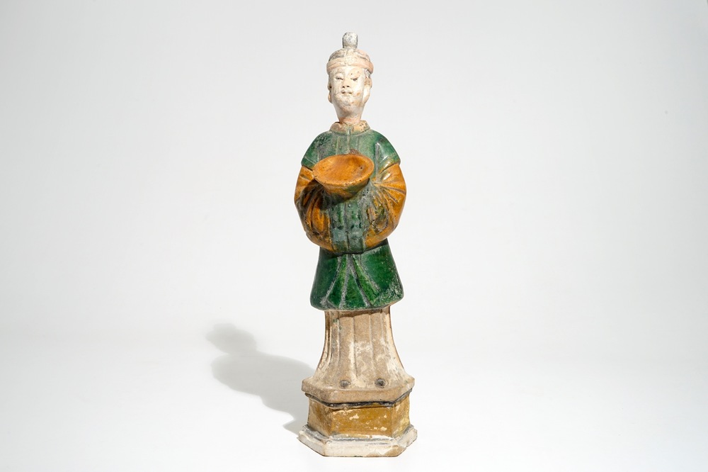 Een Chinese sancai figuur van een dienaar op sokkel, Ming