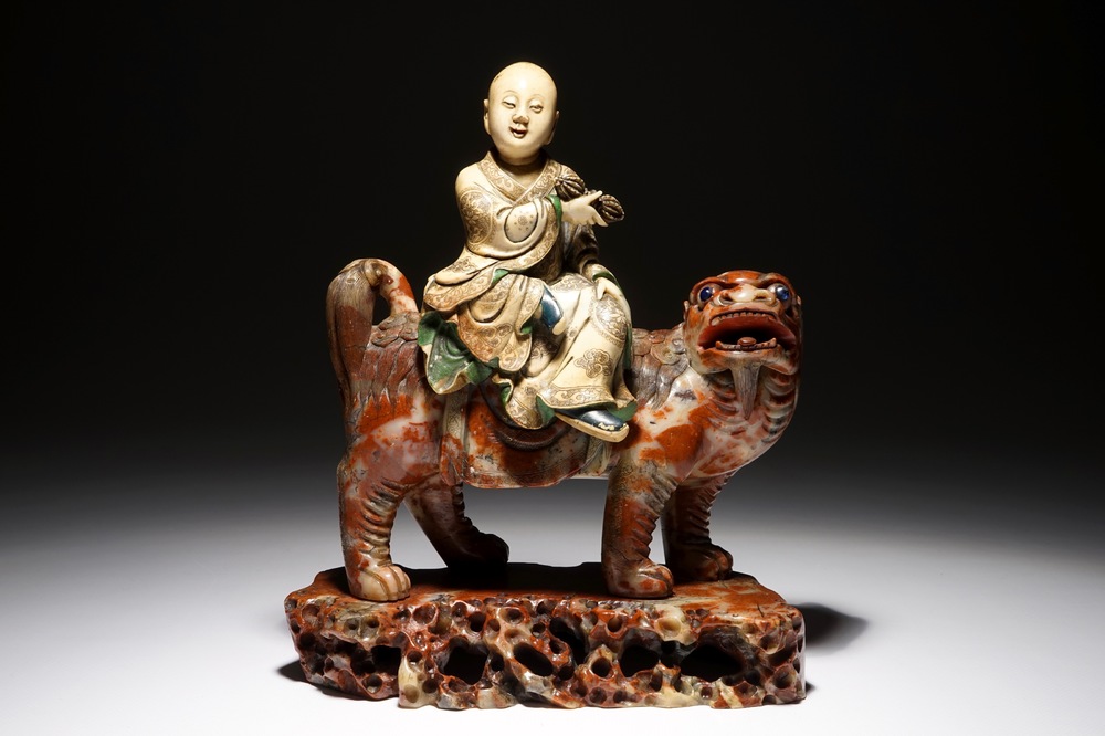 A Chinese soapstone figure of the immortal Vajraputra on a Buddhist lion, Kangxi/Qianlong