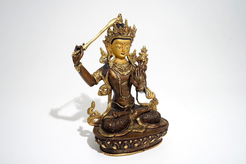A Sino-Tibetan gilt bronze figure of Manjusri with coral and turquoise insets, 19/20th C.