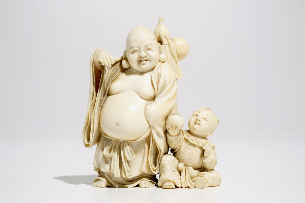 A Chinese ivory group of Buddha with a boy, signed, late 19th C.