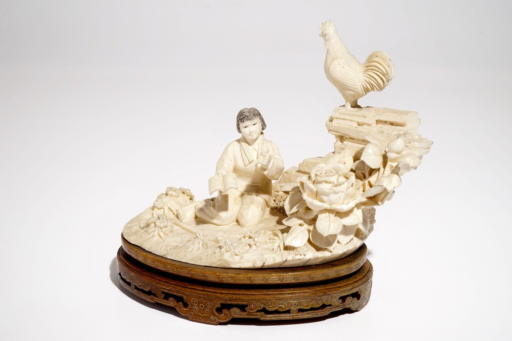A Chinese ivory group with a girl on a wooden stand, 2nd quarter 20th C.