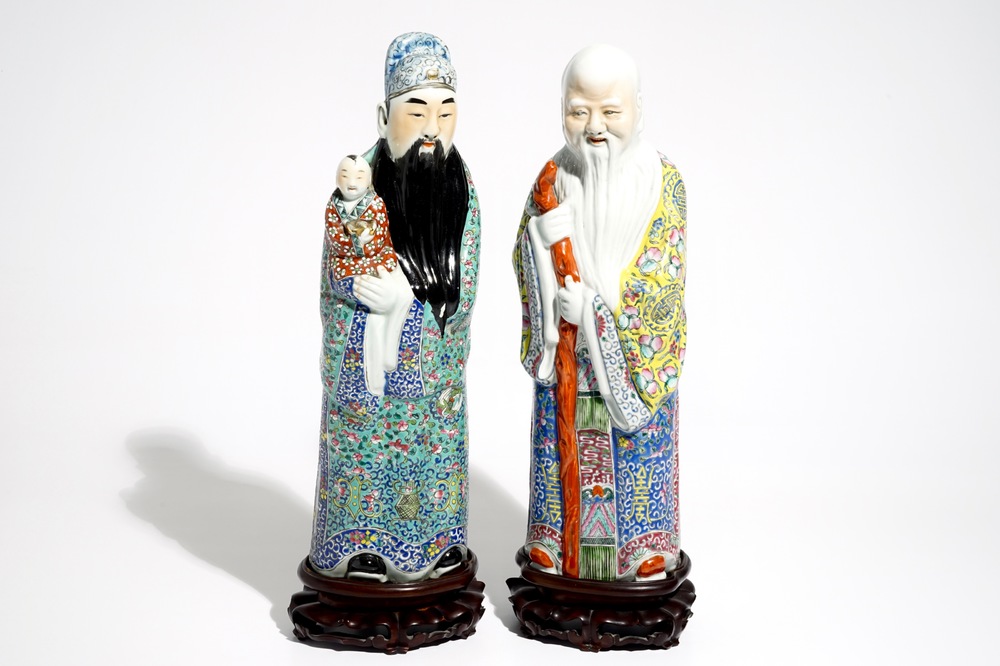A pair of Chinese famille rose figures of immortals on wooden bases, 19/20th C.
