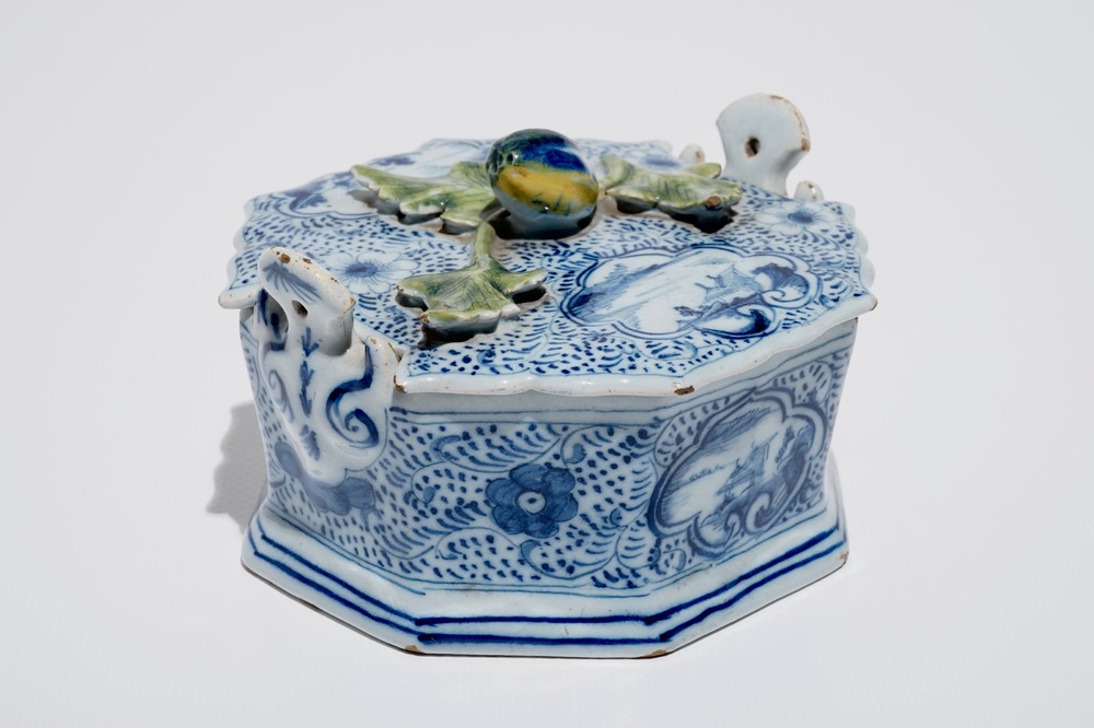 A Dutch Delft blue and white butter tub with polychrome finial, 18th C.