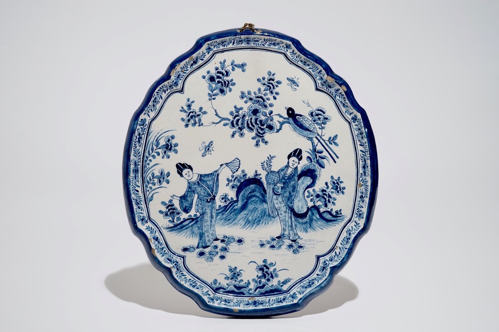 A Dutch Delft blue and white chinoiserie plaque with two ladies, 18th C.