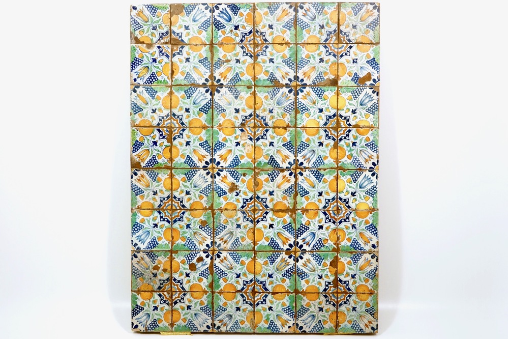 A field of 48 polychrome Dutch Delft tiles with tulips, pomegranates and grapes, 17th C.