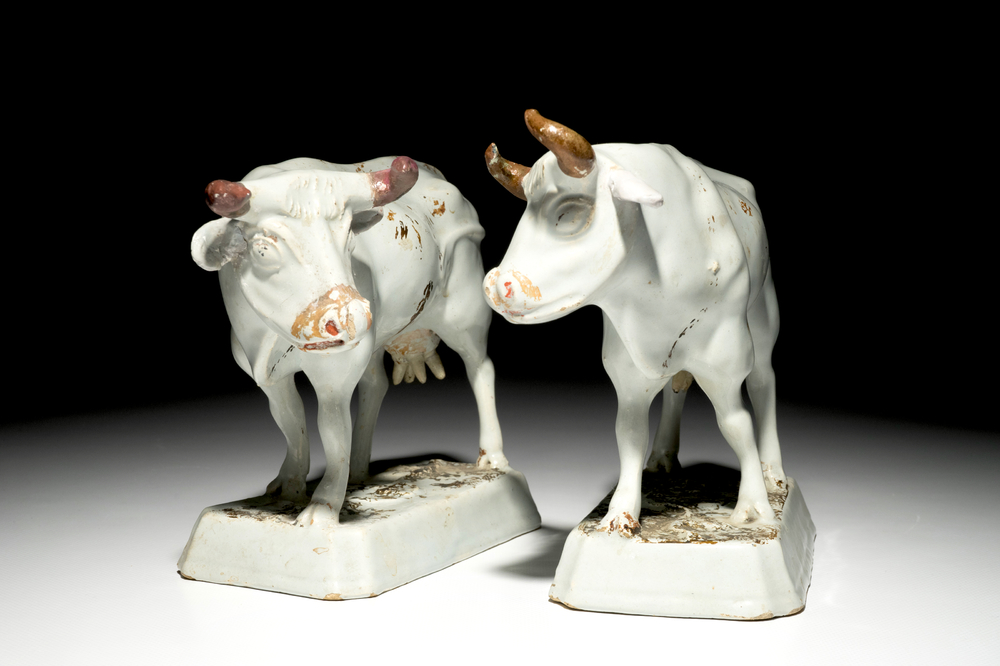 A pair of large cold-painted white Dutch Delft cows on bases, 18th C.