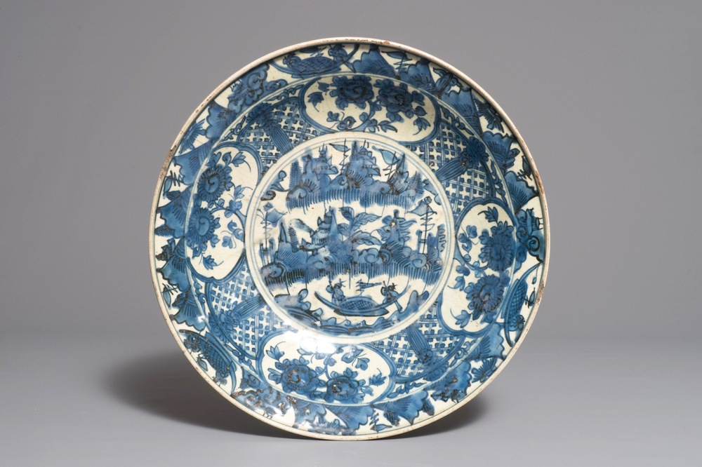 A large Chinese blue and white Swatow dish with a boat in a landscape, Ming