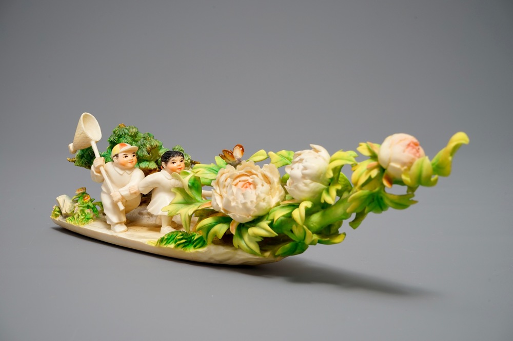 A Chinese polychrome ivory group of children hunting butterflies, first half 20th C.