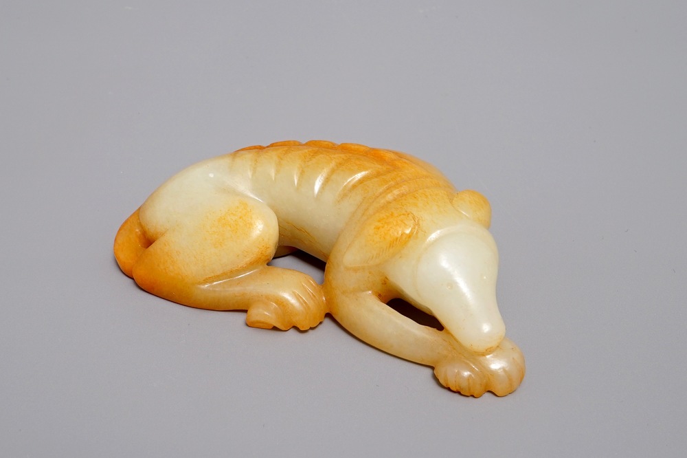 A Chinese carved russet jade model of a reclining dog, 19/20th C.