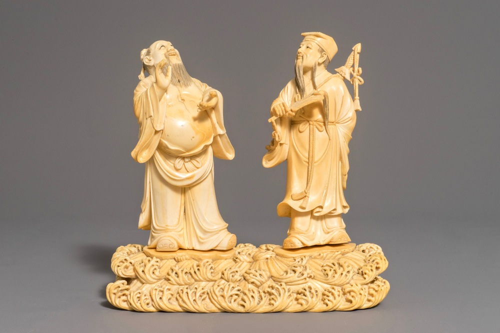 A Chinese carved ivory group of two figures on a ground, 18/19th C.