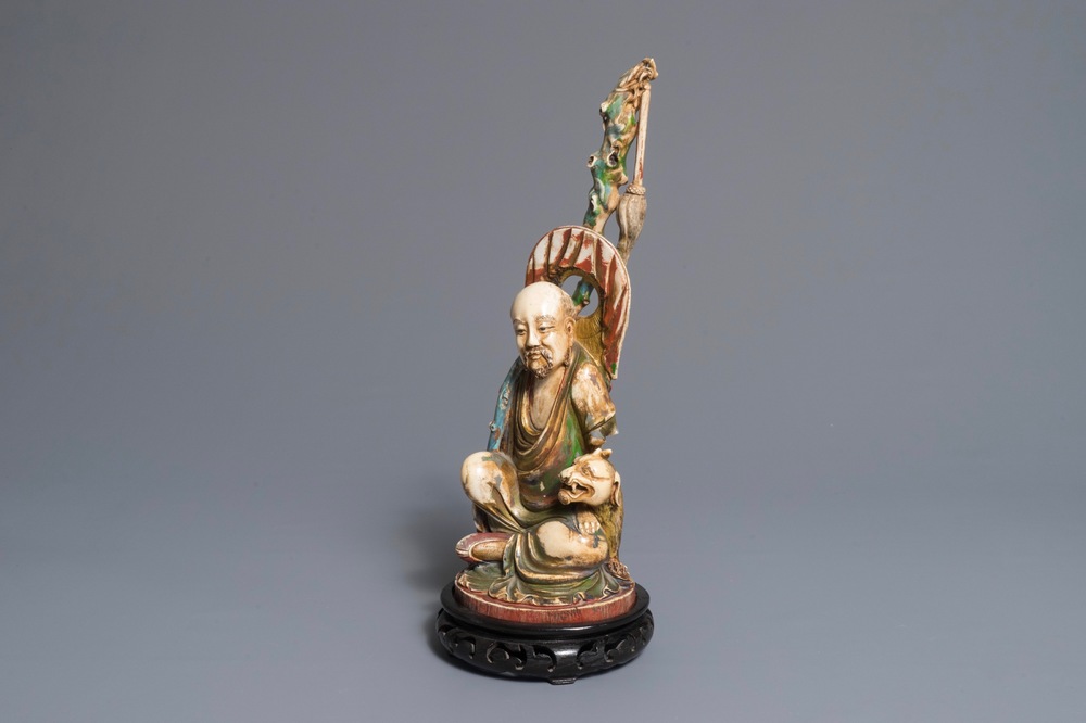 A large polychrome Chinese ivory group of a sage with a mythical beast, 19th C.