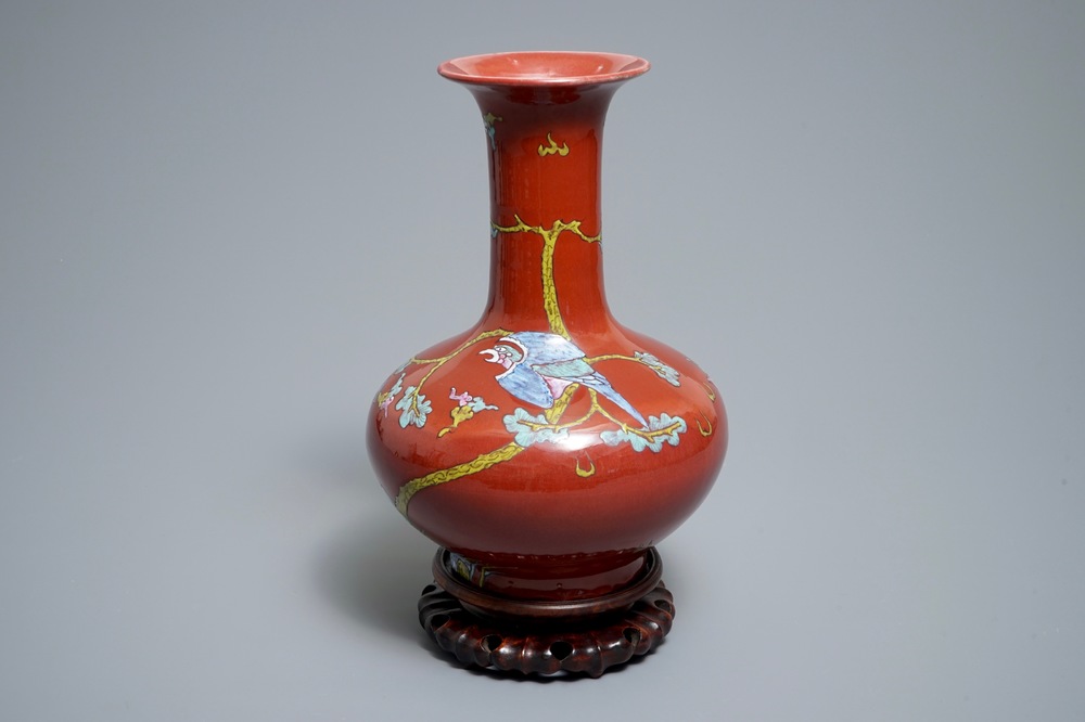 A Chinese oxblood-glazed bottle vase with an overglaze design of a qilin and a bird, 19th C.