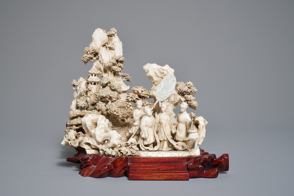 A Chinese ivory group of figures in a landscape on carved wooden base, 1st half 20th C.