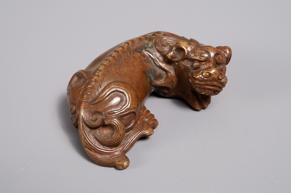 A Chinese bronze scroll or paper weight shaped as a Buddhist lion or Shishi, 17/18th C.