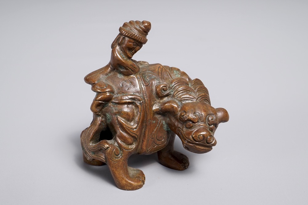 A Chinese bronze scroll or paper weight shaped as a mythical beast with rider, 19/20th C.