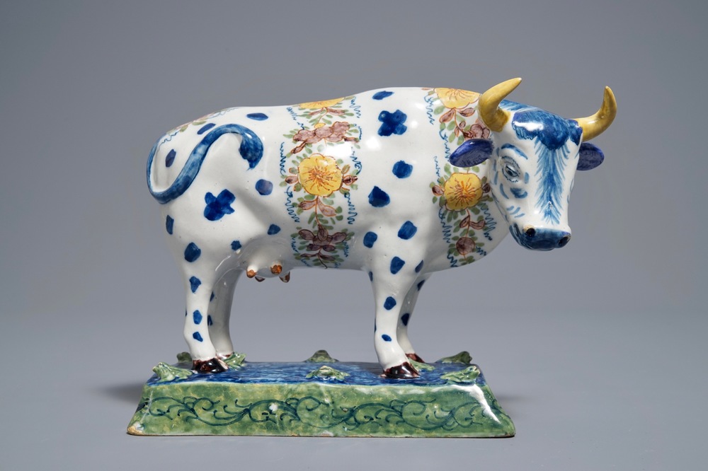 A polychrome Dutch Delft cow on a base with frogs, 18th C.