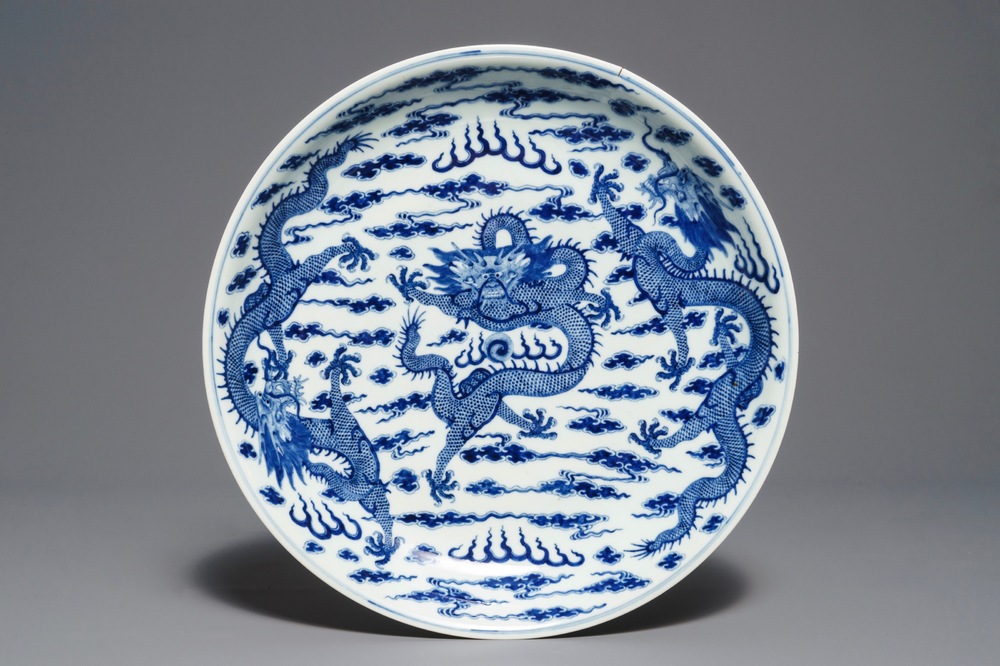 Un plat en porcelaine de Chine bleu et blanc &agrave; d&eacute;cor de dragons, marque de Kangxi, 19&egrave;me