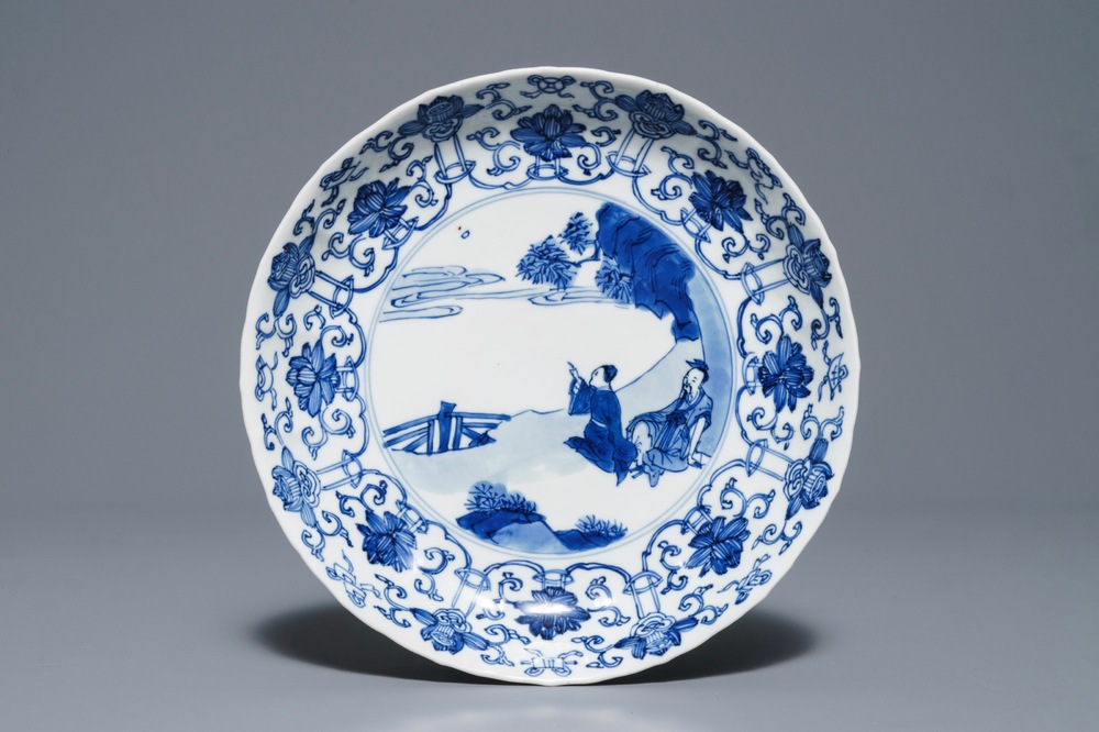 Een Chinees blauwwit gelobd bord met figuren in een landschap, Kangxi merk en periode