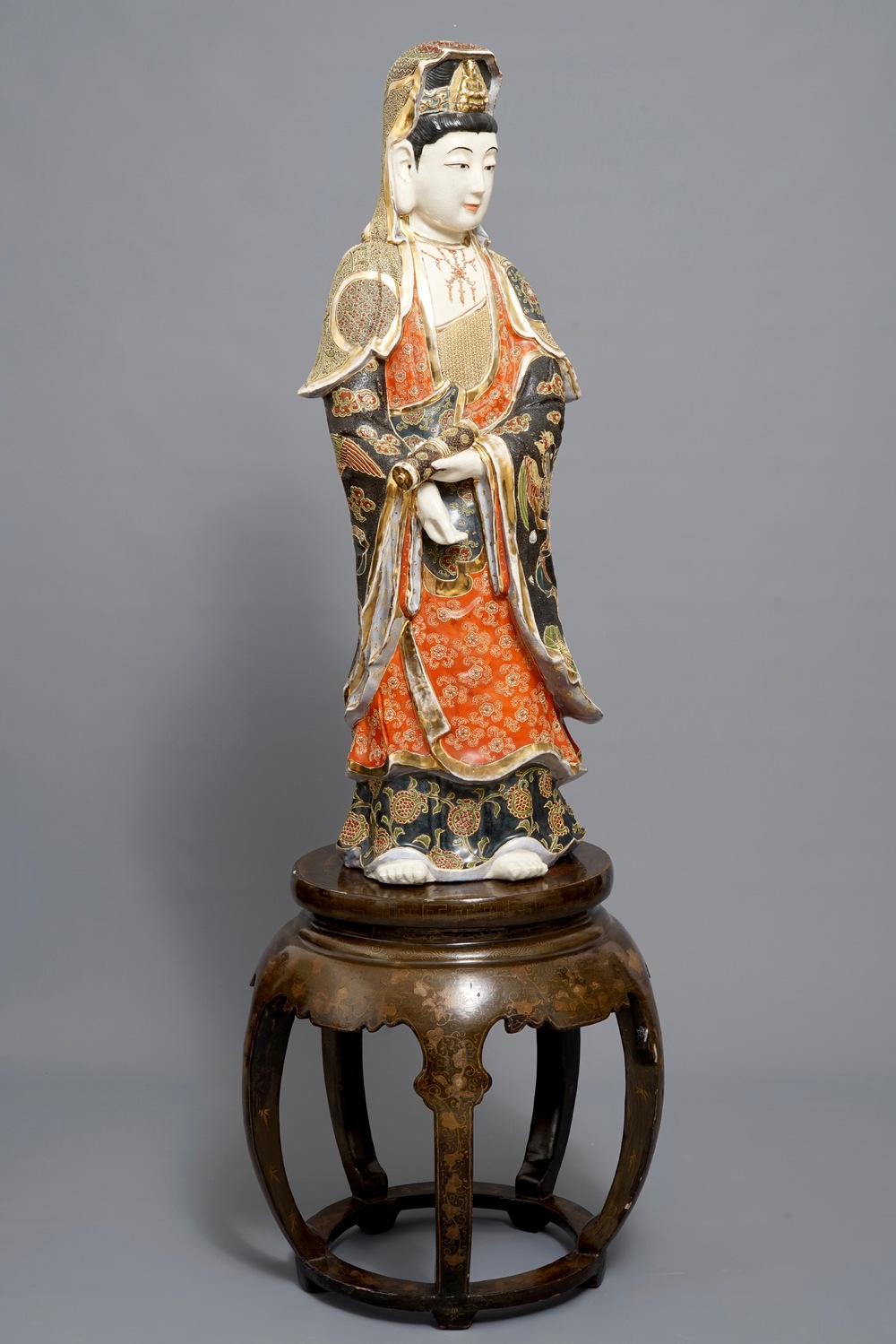 A large Japanese Satsuma figure of Kannon on laquered wooden stand, Meiji, 19/20th C.