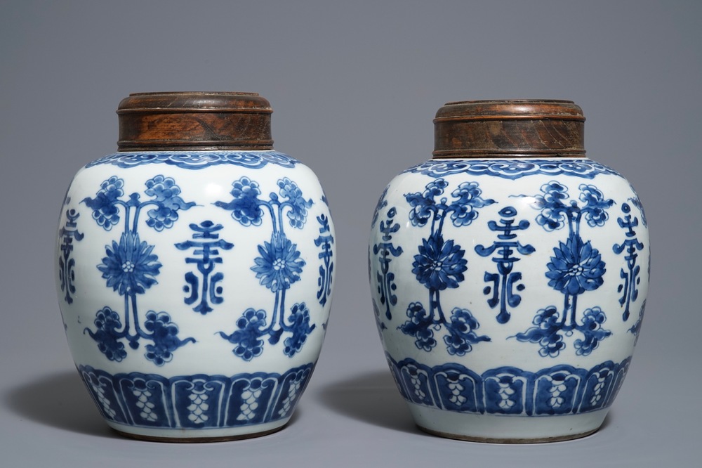 Une paire de pots en porcelaine de Chine bleu et blanc aux couvercles en bois, 18/19&egrave;me