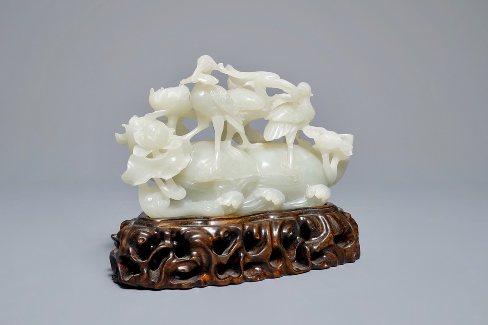 A Chinese celadon jade 'cranes' group on carved wooden base, Qing