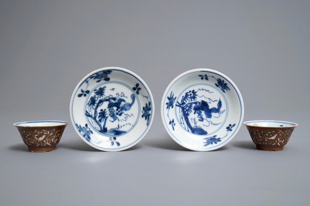 Une paire de tasses et soucoupes en porcelaine de Chine bleu et blanc &agrave; d&eacute;cor grav&eacute; sur fond brun capucin, Kangxi