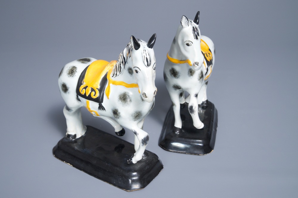 A pair of polychrome Dutch Delft black and yellow models of circus horses, 19th C.