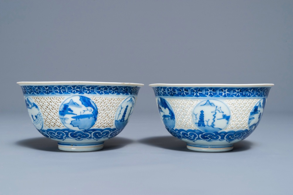 A pair of Chinese blue and white reticulated bowls with landscape panels, Transitional period