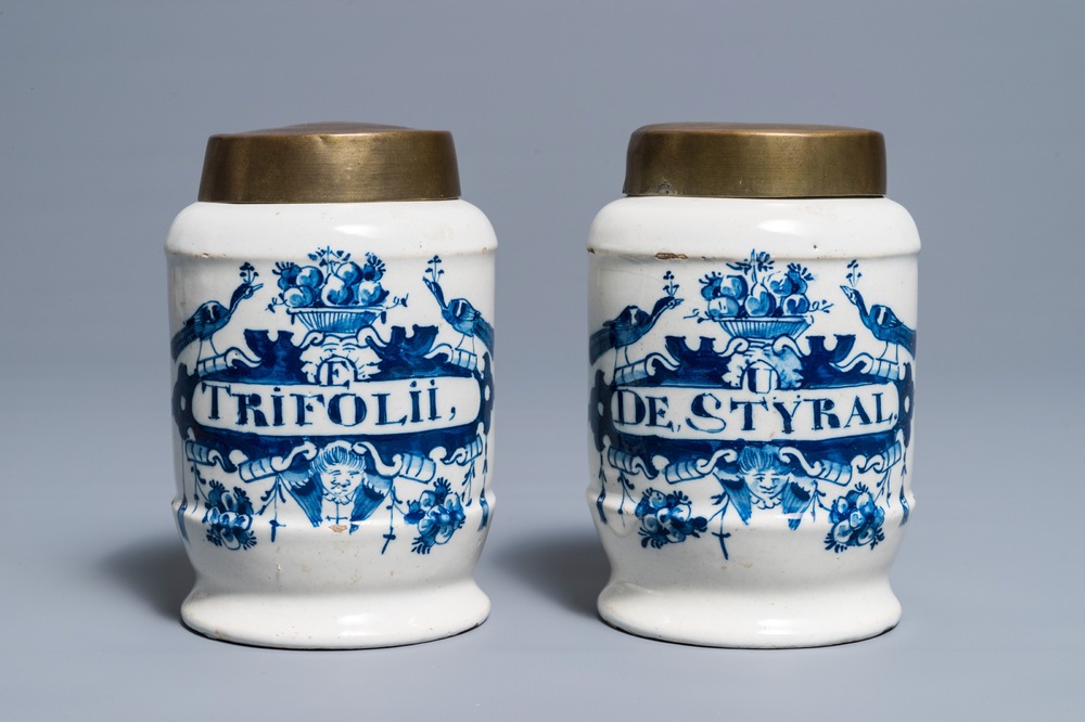 Une paire de pots de pharmacie en fa&iuml;ence de Delft bleu et blanc aux couvercles en laiton, 18&egrave;me