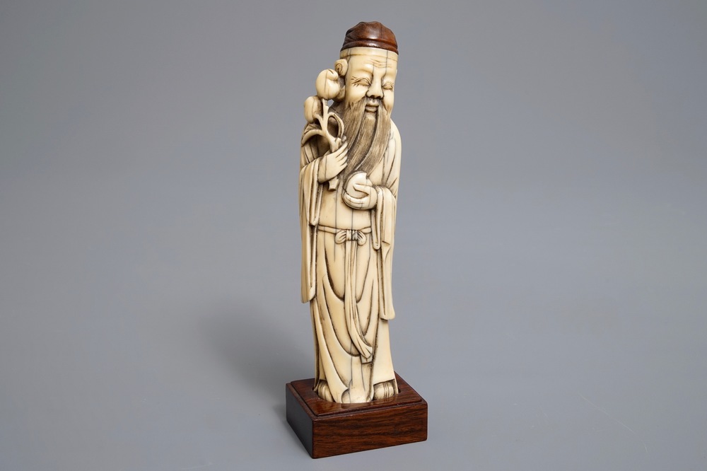 A Chinese Ming style carved ivory figure of a scholar, 19th C.