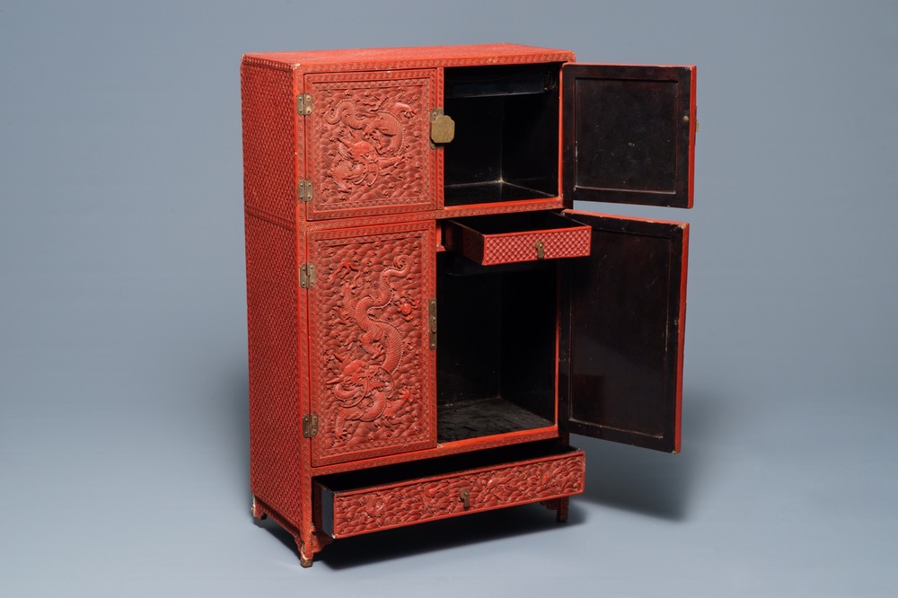 A Chinese cinnabar 'dragons and phoenixes' lacquer cabinet, 19th C.