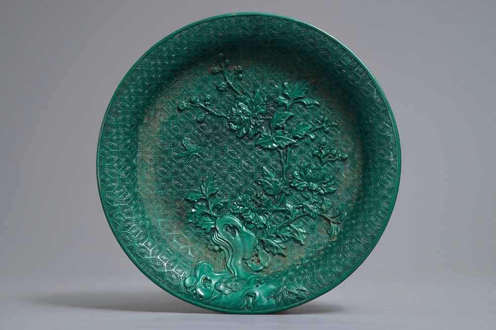 Een Chinees groen lakwerk bord met floraal decor, 19/20e eeuw