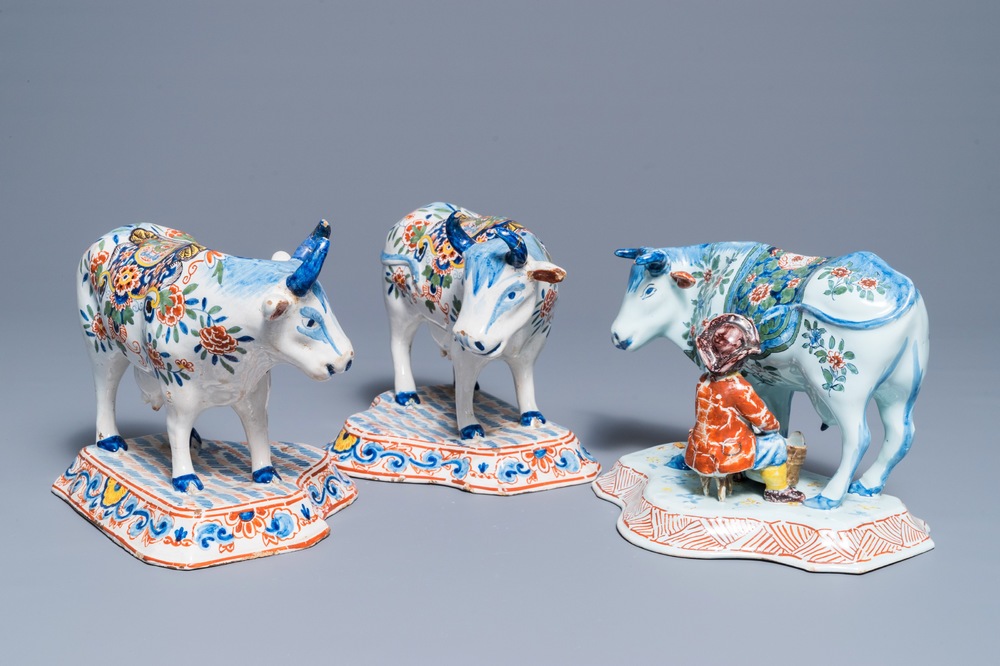 A pair of polychrome Dutch Delft models of cows and one with a milker, 19th C.